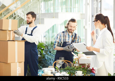 Female manager making notes in report while taking delivery Stock Photo