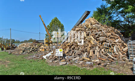 Piled  cut & slplit 'Oak' firewood for sale, conveyor, Mike's Fix - It - Shop. Stock Photo