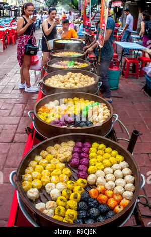 Street food vendor sells steamed Asain dumplings cooking in a wooden steamer on Jalan Alor, Food Street, in Bukit Bintang, Kuala Lumpur, Malaysia. Stock Photo