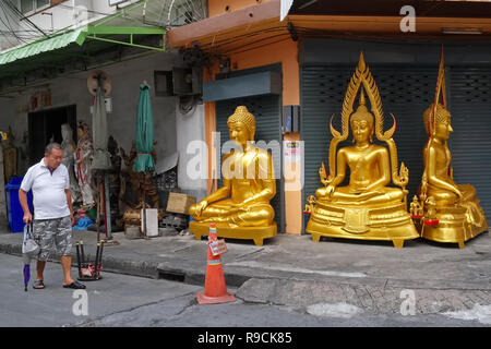 A man passes a factory for Buddha statues in Bamrung Muang Road, Bangkok, Thailand, a centre for the sale of religious objects Stock Photo