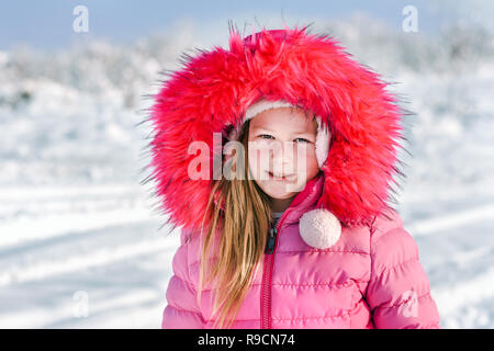 Portrait of a little girl in the snow on a sunny winter day. Stock Photo