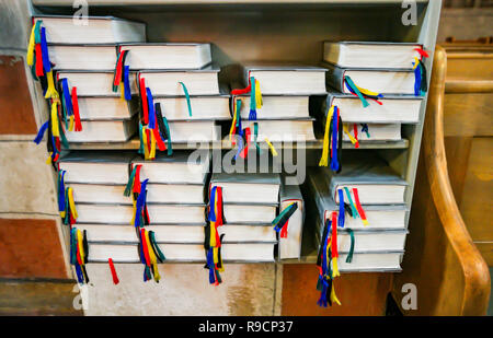 Hymnals with colorful bookmarks in a wooden shelf Stock Photo