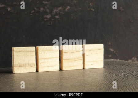 Blank wood scrabble pieces isolated on grunge black background. Stock Photo