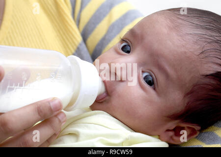 Mother feeding milk to newborn baby Stock Photo