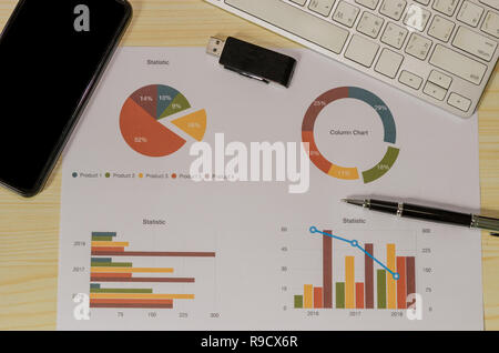 business documents papers Graph and pen, computer keyboard and smartphone on desk. Stock Photo