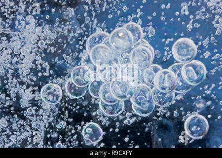 Big and small gas bubbles captured in blue ice Stock Photo