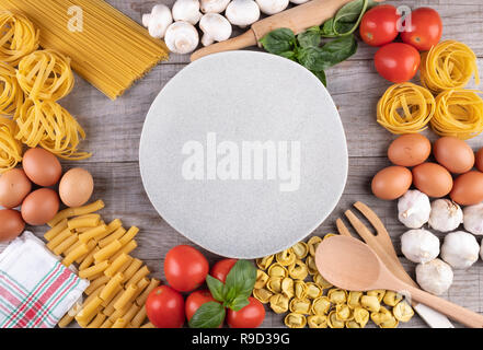 pasta, vegetables, eggs, with dish in the middle on wooden background Stock Photo