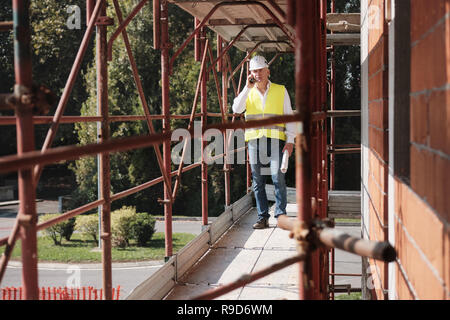 Engineer Talking On Mobile Phone In Construction Site Stock Photo