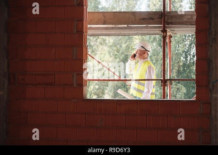 Engineer Talking On Mobile Phone In Construction Site Stock Photo