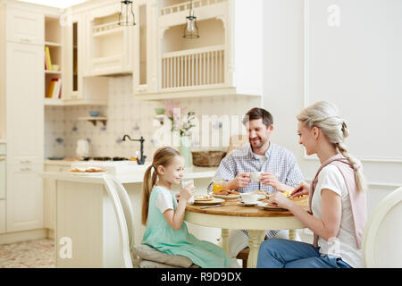 Happy family having breakfast together Stock Photo