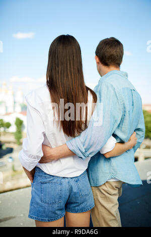 Couple embracing each other and looking into distance Stock Photo