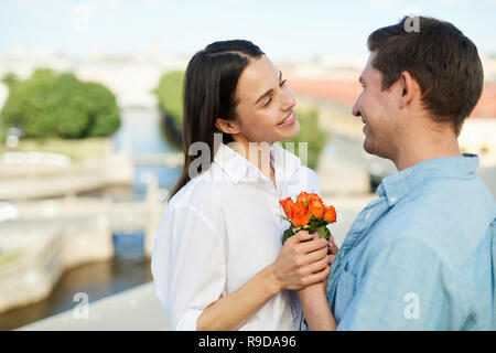 Happy man giving flowers to girlfriend Stock Photo