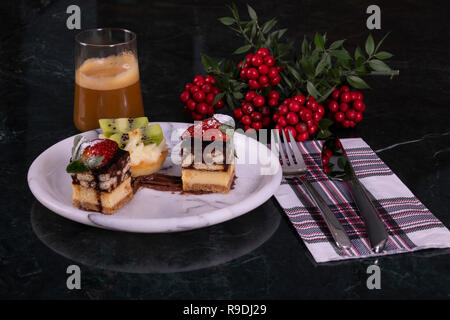 Tiny cupcake with kiwi, whipped cream and chocolate cake with coffee on a black marble table Stock Photo