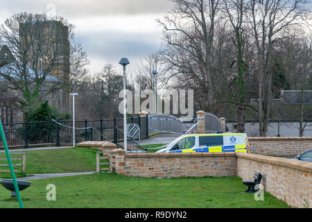 Elgin, UK. 23rd Dec, 2018. This is the scene of the Police Incident/Crime Scene on the Footbridge that takes pedestrains from King Street over the River Lossie to Cathedral Court/Newmill Road, Elgin. This is a very popular walkway from the Town Centre to the Kingsmills and surrounding area. The Bridge is sealed and guarded by 2 Police Officers and n area of the footpath has cones with protective plastic covering a small area.  © Credit: JASPERIMAGE/Alamy Live News Stock Photo