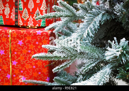 Few branches of Christmas tree and big red boxes with Christmas gifts Stock Photo