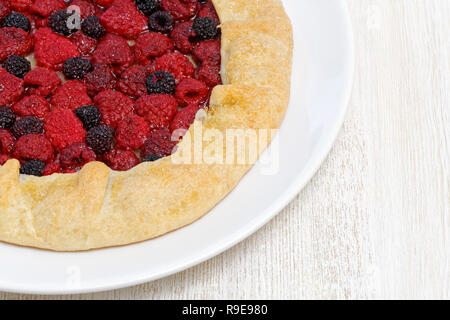 Closeup galette with red and black raspberries on white wooden table Stock Photo