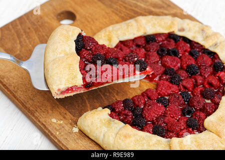 Homemade raspberries pie with a piece cut off Stock Photo