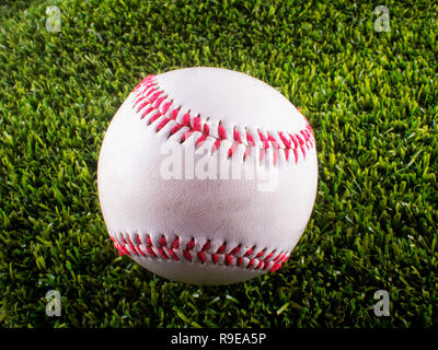 Baseball over synthetic green grass, close up Stock Photo