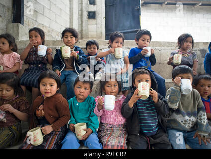 Guatemalan indigenous children drink a cup of atole at preschool in Tierra Linda, Solola, Guatemala. Stock Photo