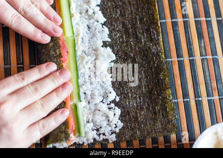 Sushi ingredients, nori seaweed on makisu bamboo mat for rolling, fresh raw  salmon, raw sushi rice, soy sauce and chopsticks on the side Stock Photo -  Alamy