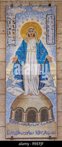 A mosaic painting depicting Mary and the infant Jesus donated by the Catholic community of Egypt in style that boldly reflect the culture of the country and visualize the annunciation in its own local eyes hanging on the wall around the front courtyard of the Roman Catholic Church of the Annunciation or the Basilica of the Annunciation in the city of Nazareth in Galilee northern Israel. Stock Photo