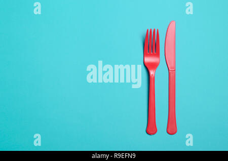 Red Fork and Knife on Bright Blue Background, Single Use Cutlery Concept Stock Photo