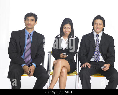 PORTRAIT OF THREE CORPORATE EXECUTIVES  TALKING ON MOBILE Stock Photo