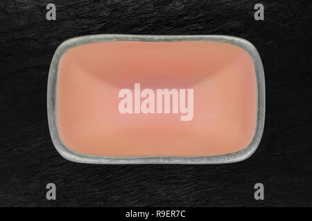 Top view of rectangular pink empty dish with silver edges on black stone background Stock Photo