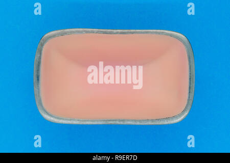 Top view of rectangular pink empty dish with silver edges on blue background Stock Photo