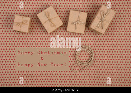Celebratory concept - gift boxes, text "Merry Christmas & Happy new year", decorative handmade collection of craft paper with rope on craft paper back Stock Photo