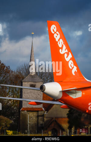 easyjet Airbus jet airliner plane at London Southend Airport, Essex, UK. Logo on tail. Church near airport Stock Photo