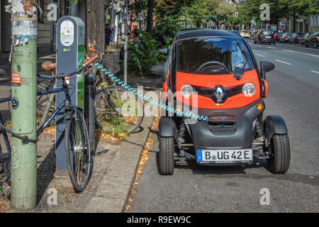 Berlin-Mitte. Renault Twizy electric car at charging point. Tiny two-seater car recharges battery in city street Stock Photo