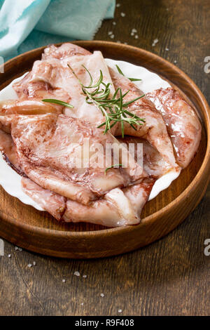 Fresh Squid, Various Spices and Olive Oil on a wooden table. Stock Photo