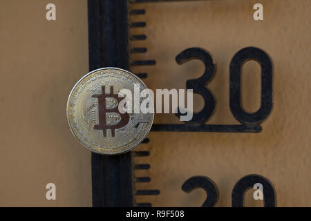 Bitcoin cryptocurrency physical coin placed on the temperature, scale meter at 30 Stock Photo