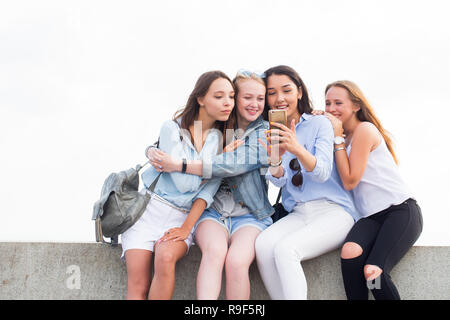 Four happy young student girls doing selfie outdoor. Friendship and modern technology concepts Stock Photo
