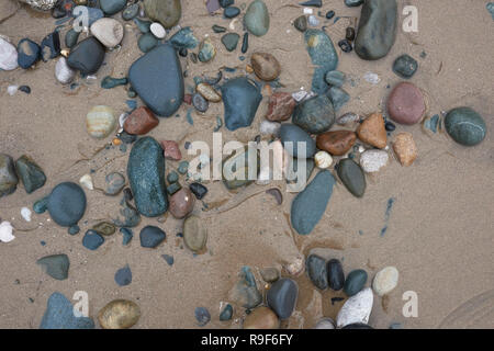 Assorted wet pebbles on cleveleys beach view from above on the fylde coast at low tide in lancashire uk Stock Photo