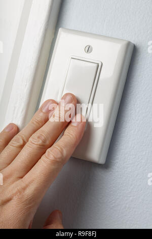 hand turning white light switch on or off Stock Photo