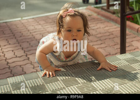 Baby girl crawling up the stairs. High angle view Stock Photo