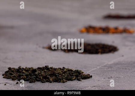 Assortment of dry tea on a gray textured background. The concept of tea drinking. Close-up. Stock Photo