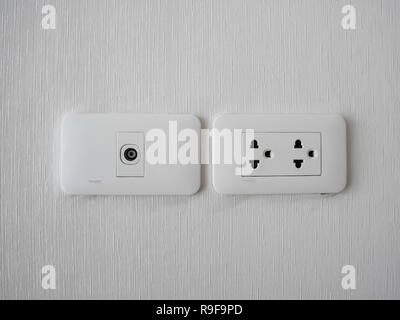 Plug Into Electricity Socket the power outlets on the wall. sockets plug outlets with 220 volts (220V) AC style. White electrical outlet on wall in th Stock Photo