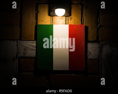 Italian flag on a brick wall under the lamp Stock Photo