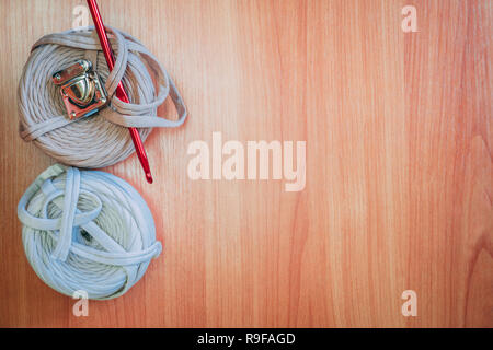 Two reel thread with red knitting hook on the desk. Top view Stock Photo