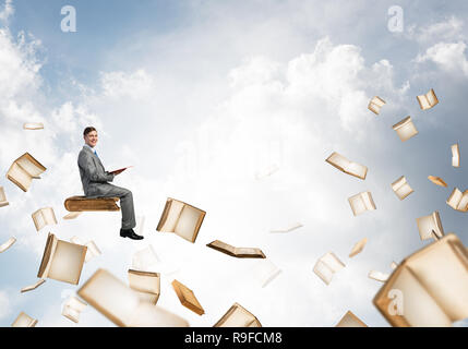 Man reading book and many of them flying in air Stock Photo