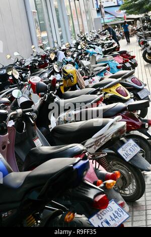 A long line of scooters filling an alleyway in Phnom Penh in Cambodia Stock Photo