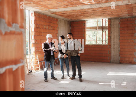 Realtor Showing New Home To Happy Married Couple Stock Photo
