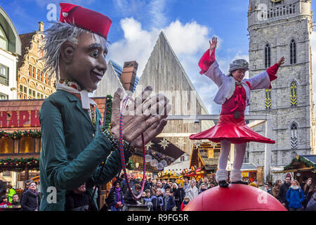 Puppeteer and street performer performing balancing act on giant ball during Christmas market in winter in Ghent, Flanders, Belgium Stock Photo