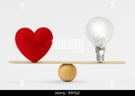 Heart and light bulb on scale - Concept of balance between heart and brain Stock Photo