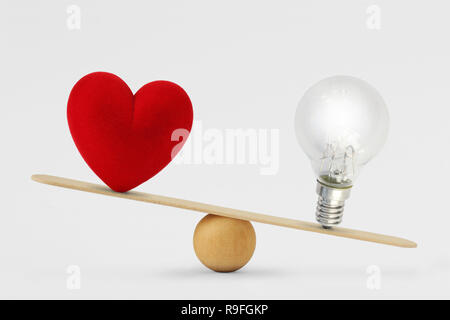 Heart and light bulb on scale - Concept of brain priority over heart in life Stock Photo