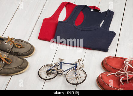 Travel and sport concept -  bicycle model, shoes, shirts, bottle of water on white wooden desk Stock Photo
