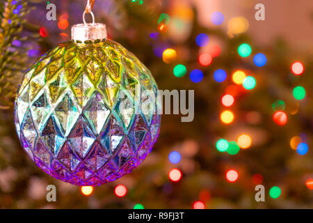 Christmas ornament ball with star on natural tree with bokeh lights background Stock Photo